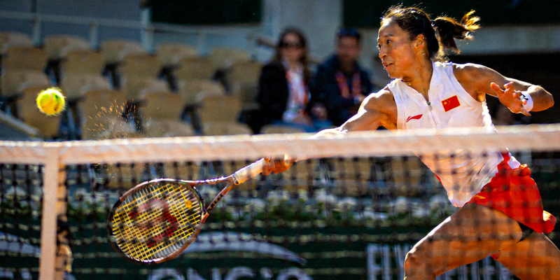 中国网球选手郑钦文在赛场上奋力击球